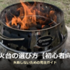 芝生の上に置かれたステンレス製の円筒型焚き火台(Petromax Atago)で炭が赤く燃え、炎が上がっている写真に、「焚き火台の選び方【初心者向け】失敗しないための完全ガイド」という記事タイトルが重なっている。