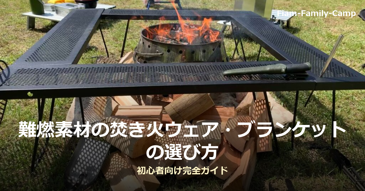 焚き火台の上で薪が燃え、オレンジ色の炎が上がっている様子。手前には割った薪が積まれ、周囲は芝生のキャンプサイト。難燃素材の焚き火ウェア・ブランケットの選び方というタイトルが写真下部に重ねられている