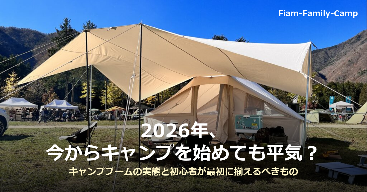 青空の下、タープとテントが張られたキャンプサイトの写真。チェアやクーラーボックスが置かれ、開放的な芝生の広場に他のキャンパーのテントも見える。2026年、今からキャンプを始めても平気？キャンプブームの実態と初心者が最初に揃えるべきものというタイトルが写真下部に重ねられている